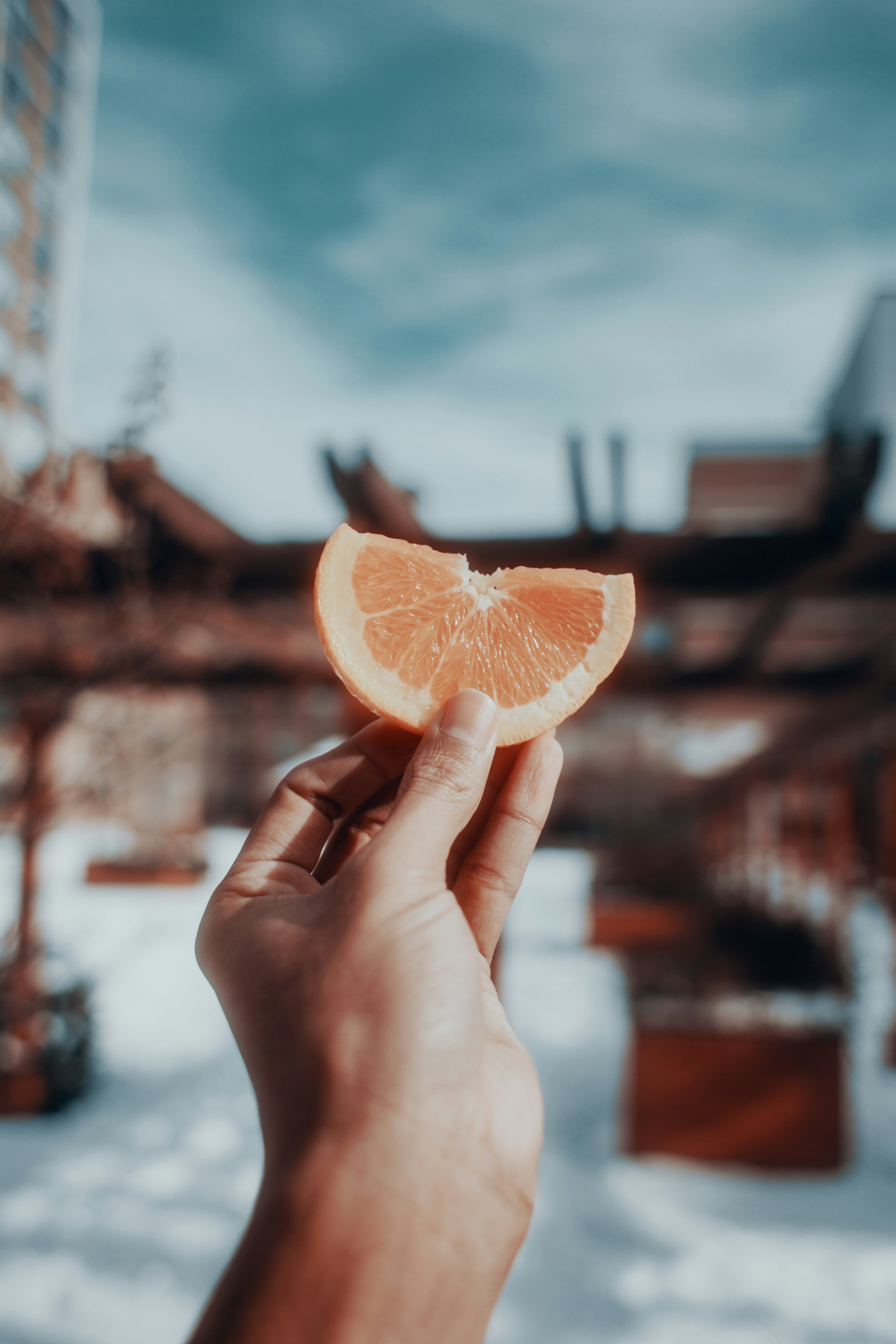 person holding sliced orange fruit